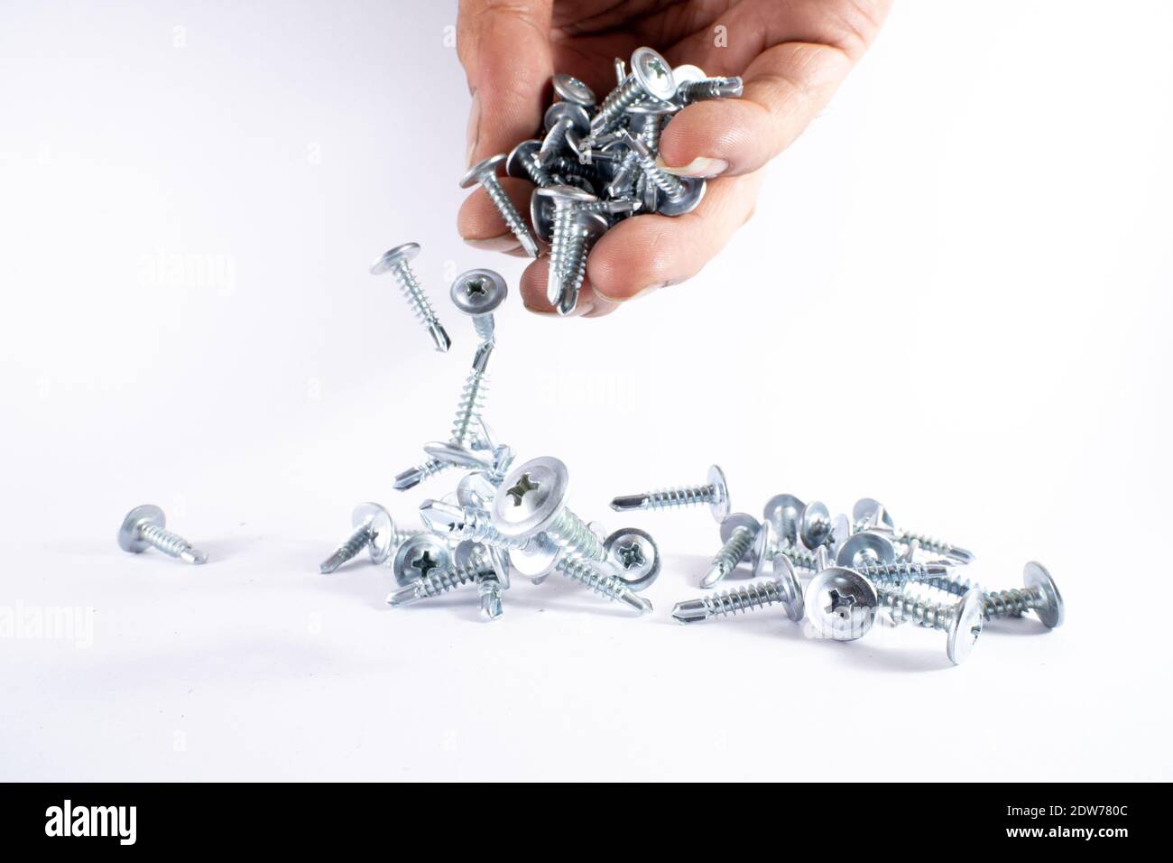 Screws Falling From Person Hand Against White Background Stock Photo Alamy
