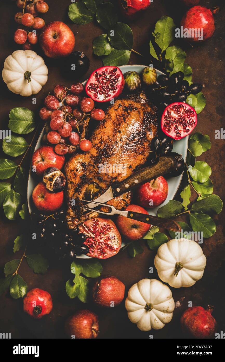 Autumn Thanksgiving, Friendsgiving, family party gathering celebration dinner. Flat-lay of Fall table with roasted duck in seasonal fruits decorated w Stock Photo