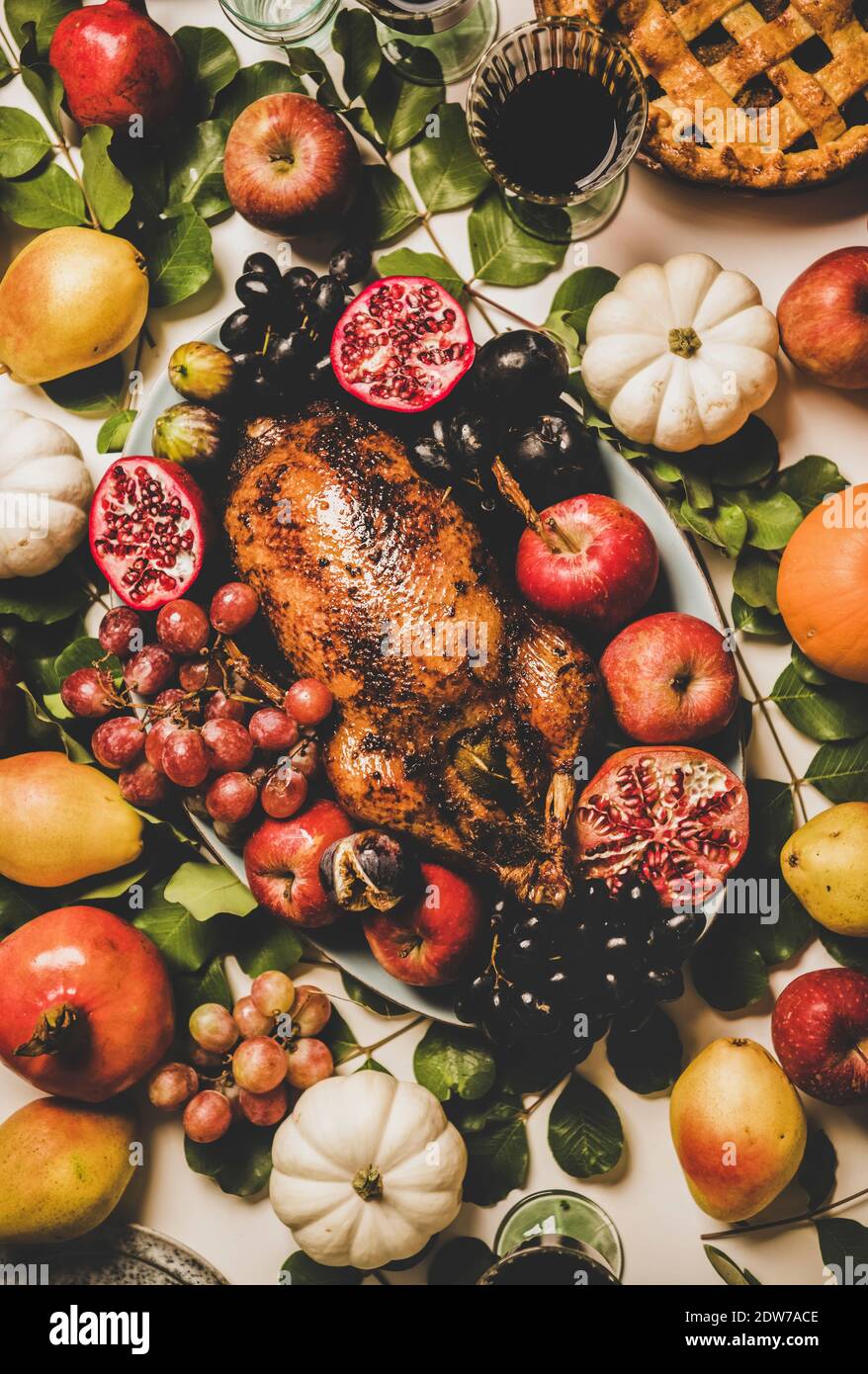 Autumn Thanksgiving, Friendsgiving, family party gathering celebration dinner. Flat-lay of Fall decorated table with roasted duck in seasonal fruits a Stock Photo