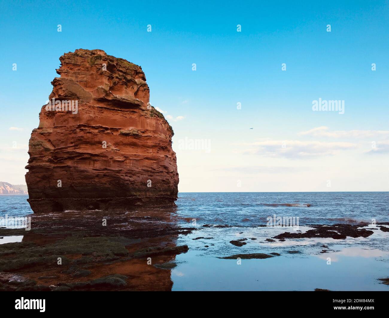Rock Formation On Sea Against Blue Sky Stock Photo