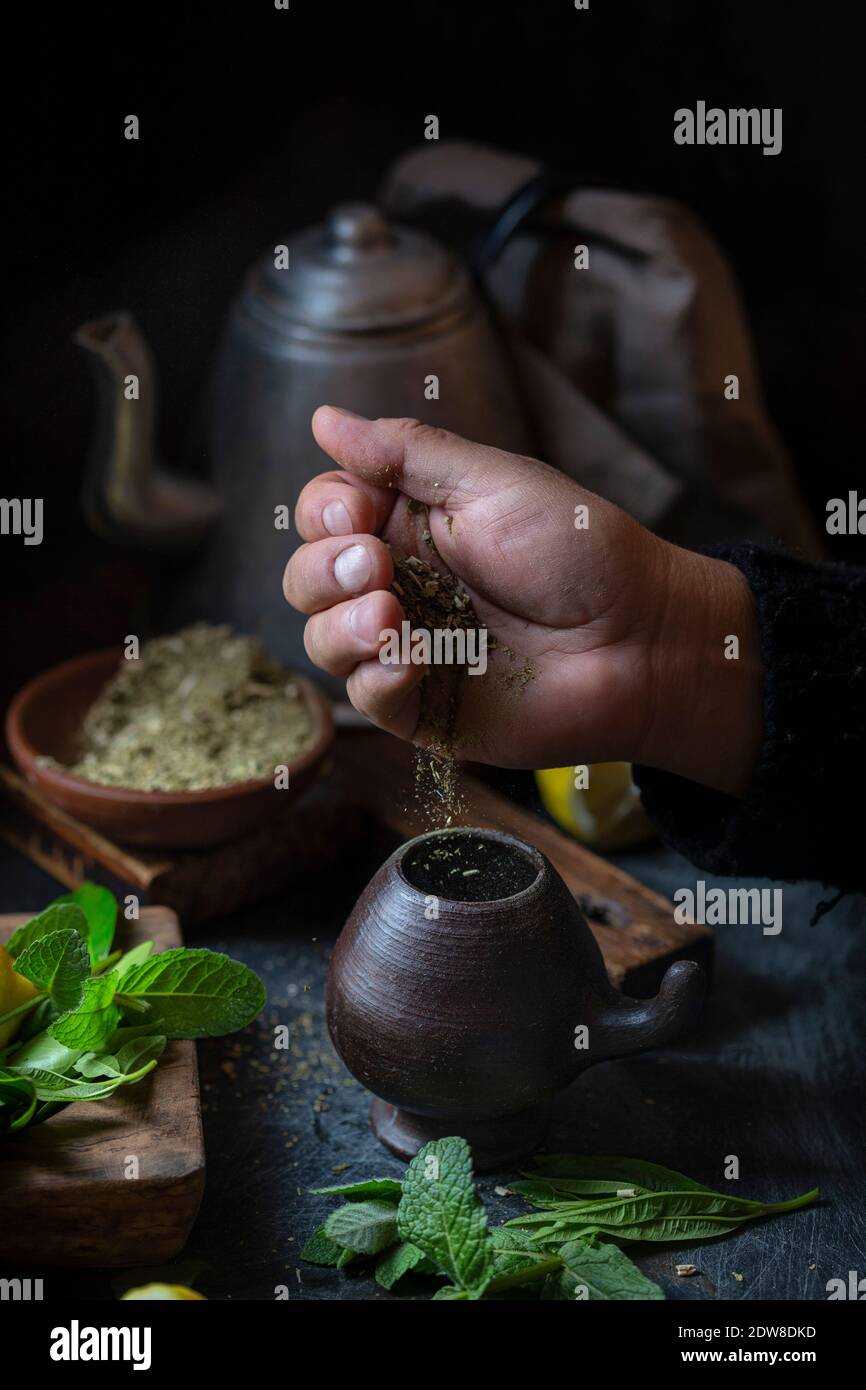 Latin American hot drink yerba mate in clay cup, herbs amd lemon. Stock Photo