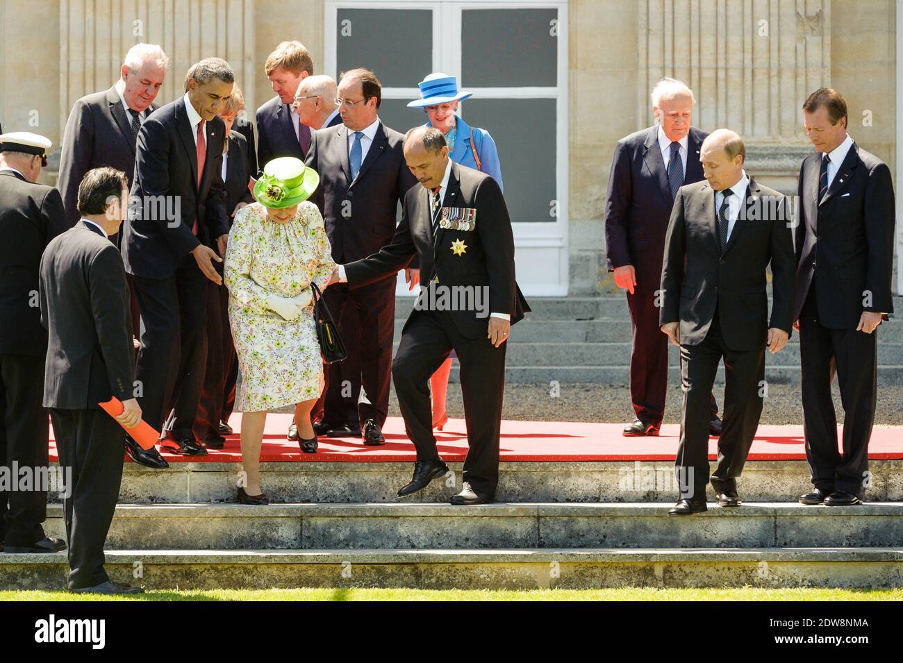 US President Barack Obama and New Zealand Governor-General Jerry Mateparae (R) help Queen Elizabeth II to her position during a group photo of world leaders attending the D-Day 70th Anniversary ceremonies at Chateau de Benouville in Benouville, France, June 6, 2014. The D-Day ceremonies mark the 70th anniversary of the launching of 'Operation Overlord', a vast military operation by Allied forces in Normandy, which turned the tide of World War II, eventually leading to the liberation of occupied France and the end of the war against Nazi Germany. Photo by Christophe Petit Tesson/Pool/ABACAPRESS Stock Photo