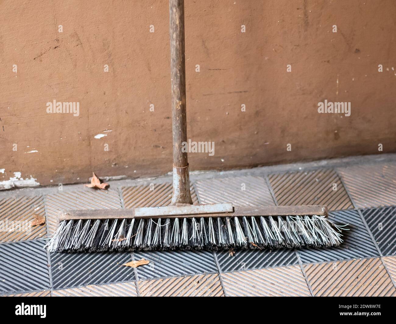 Broom Leaning Against The Wall, Selected Focus With Copy Space Stock Photo