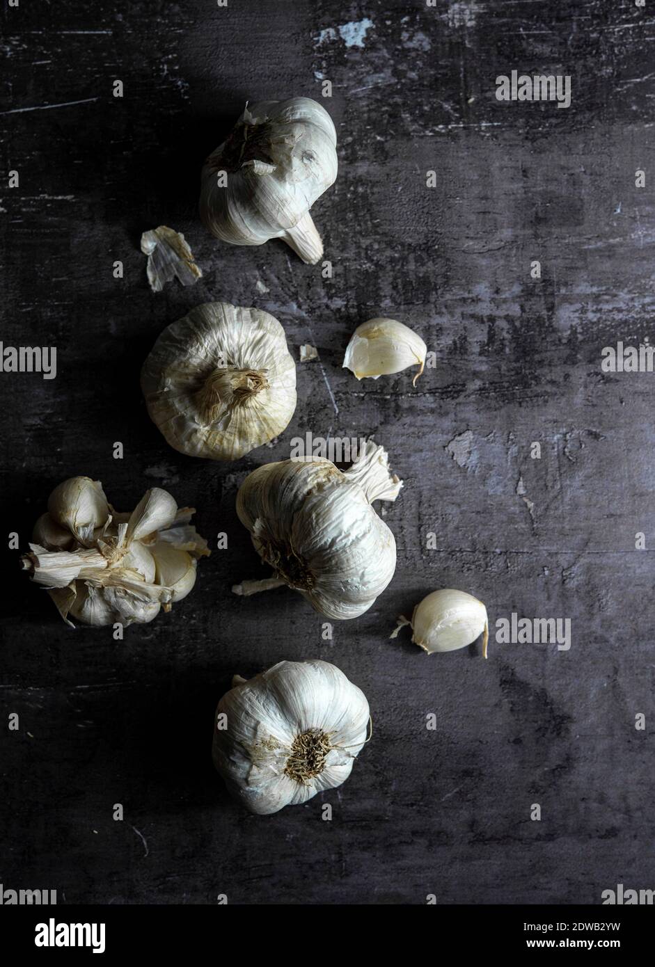 Garlic heads and cloves over dark background Stock Photo - Alamy