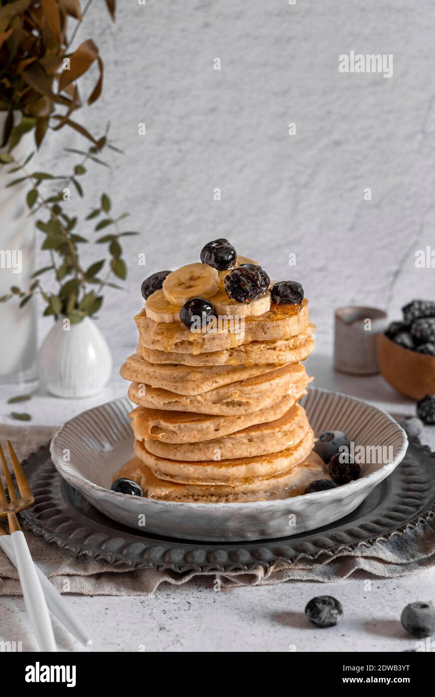 Stack of dairy free whole wheat pancakes served with honey, banana and berries Stock Photo Alamy