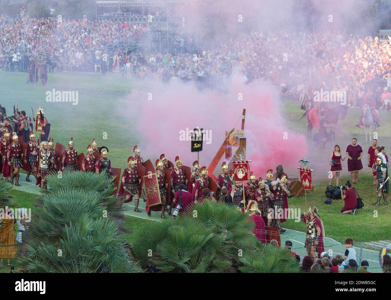 Annual festival in Cartagena, Spain is the Cartaginians and Romans. Hidden by smoke a wounded warrior is carried from the battlefield. Many onlookers. Stock Photo