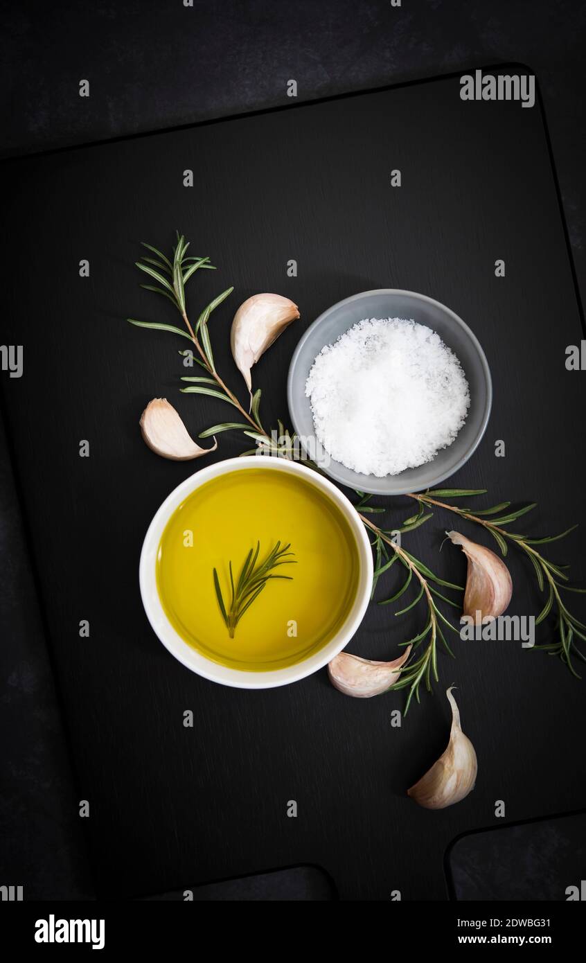 Olive oil, salt flakes, garlic cloves and rosemary Stock Photo Alamy