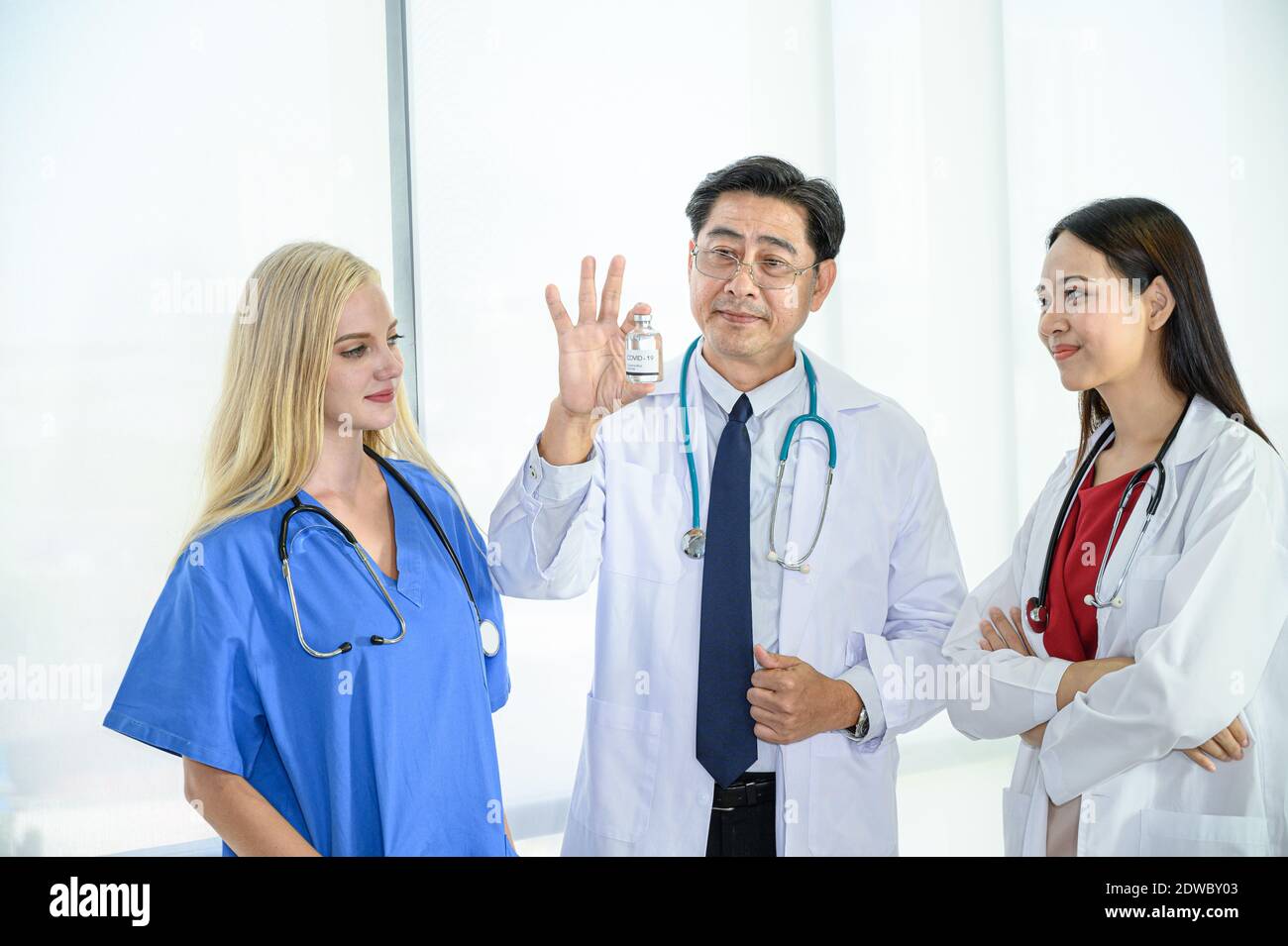 Group of doctors wearing formal white coat and blue scrubs suit, Teamwork brainstorm meeting at the hospital. Healthcare specialist people. Stock Photo