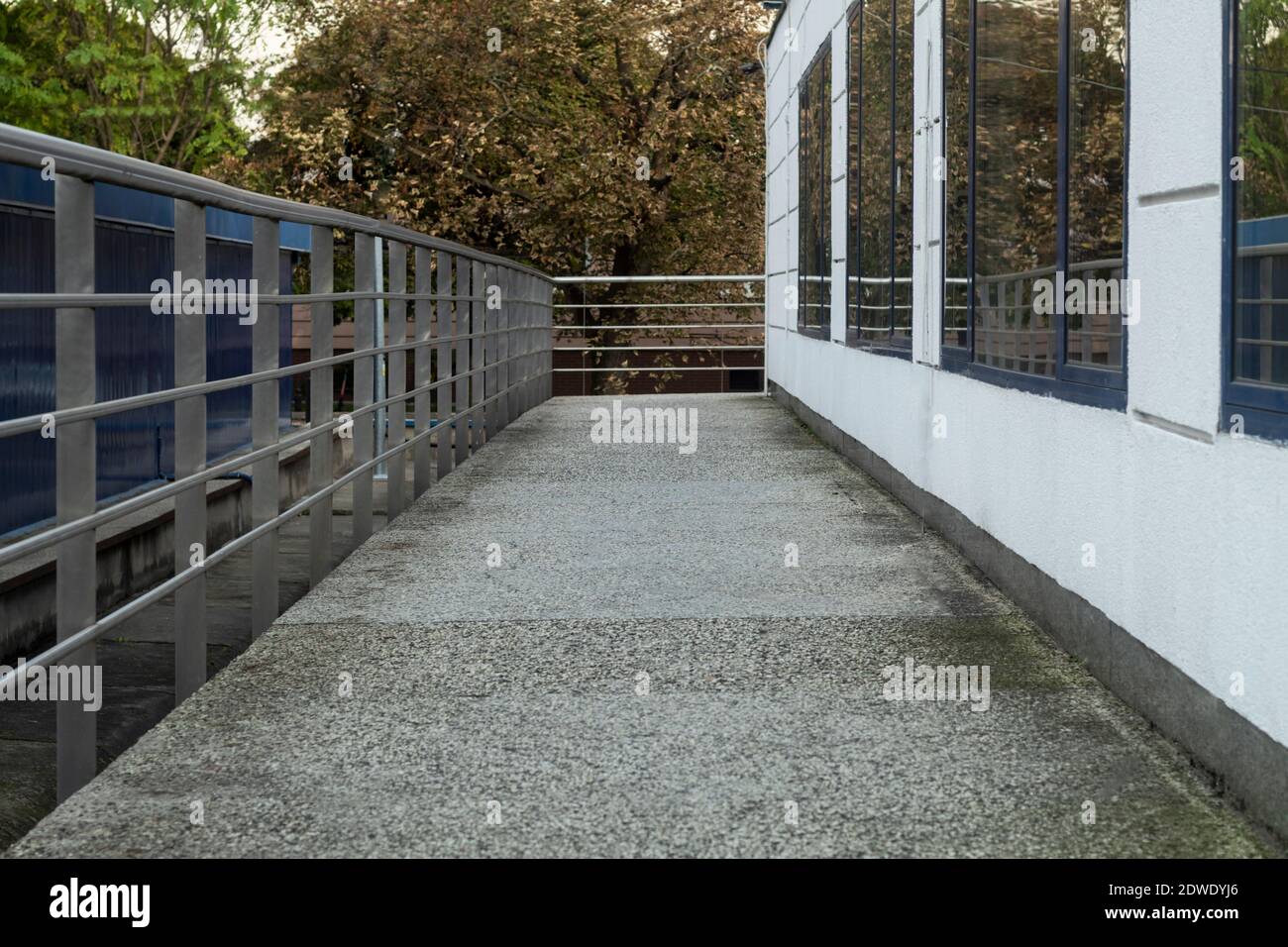 Interesting walkway with railings and wall with windows Stock Photo Alamy