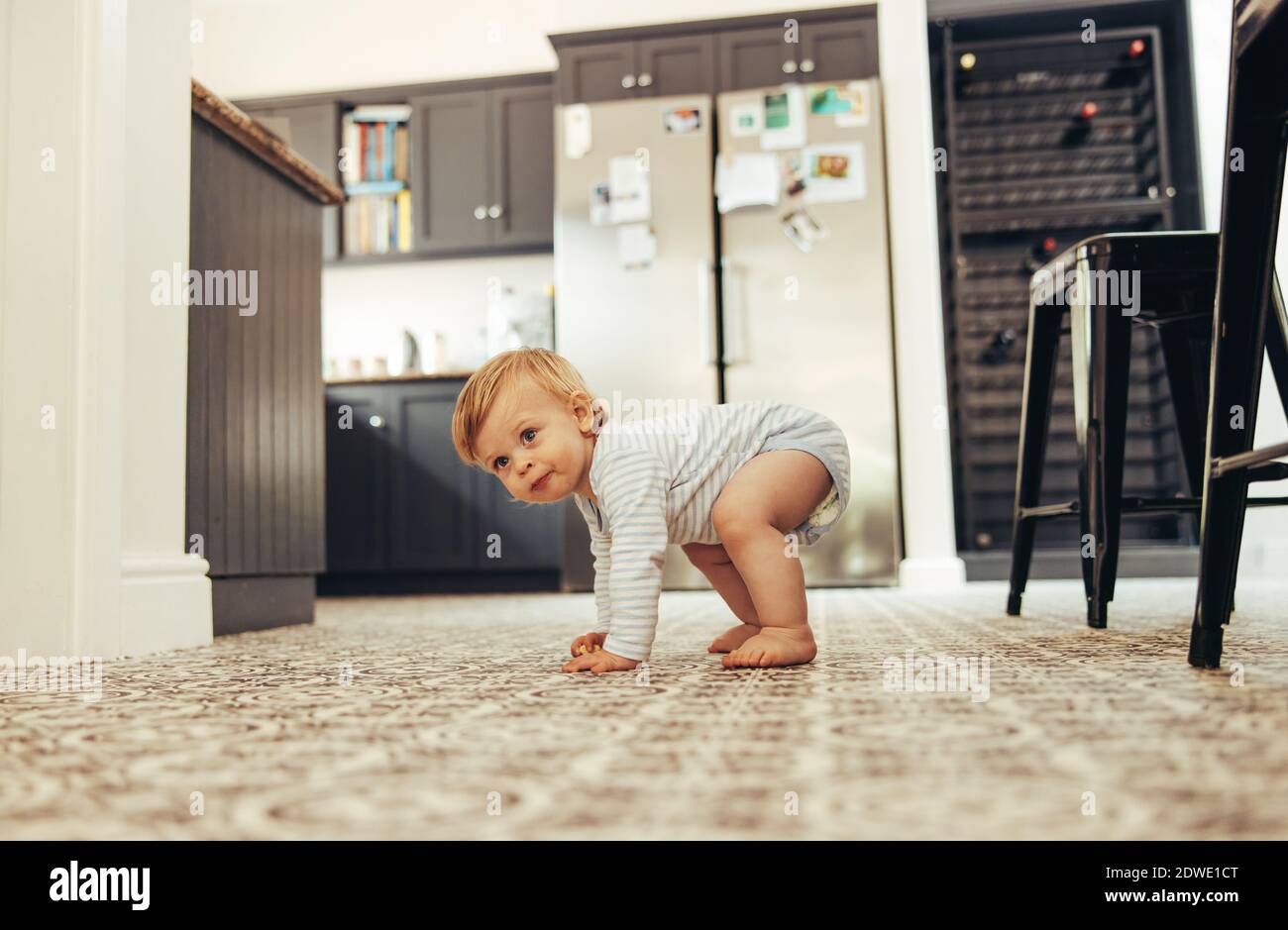 Cute baby trying to stand on his feet. Developing child standing up on