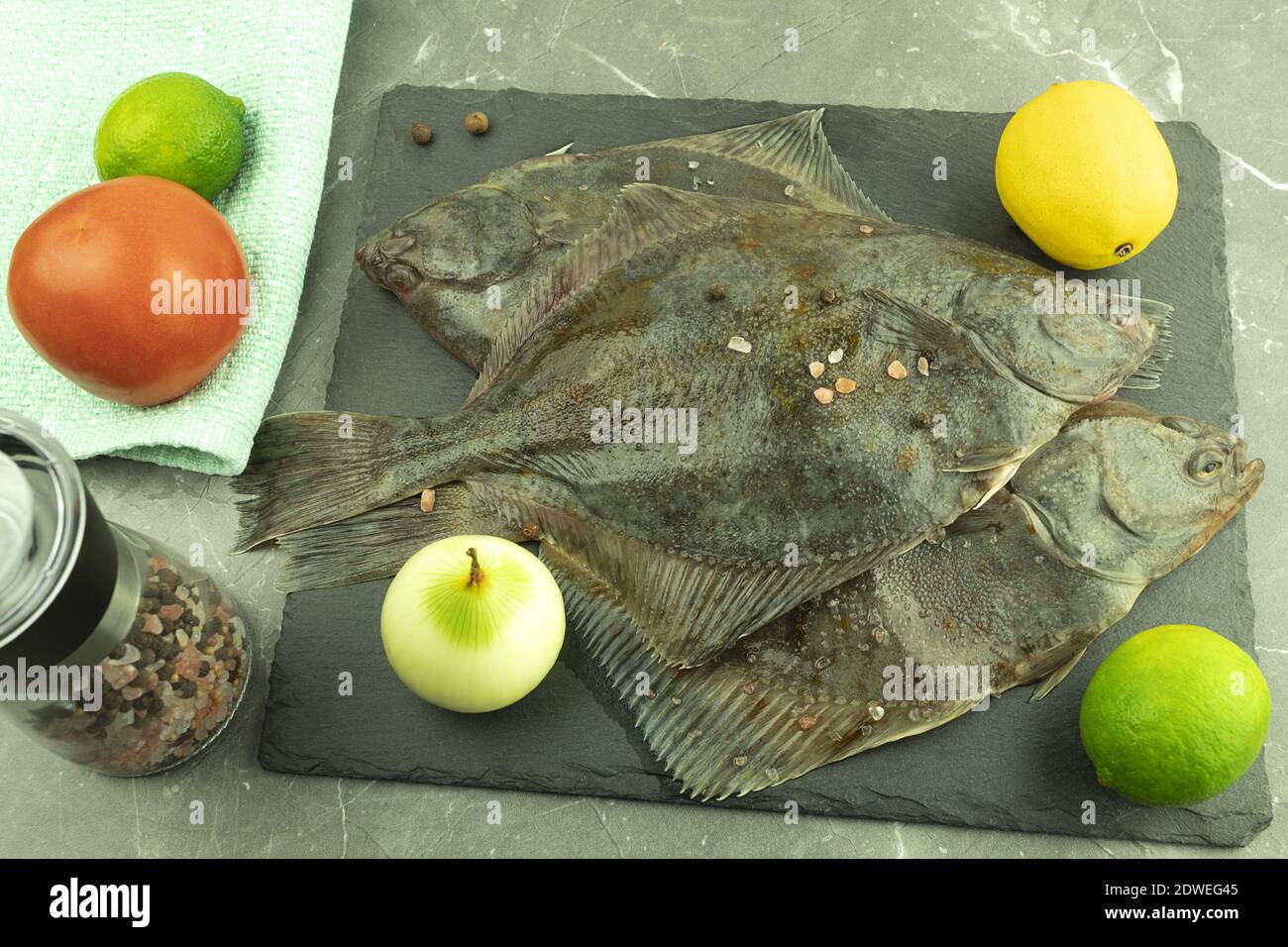 Fresh fish flounder on a table with lemon. Raw flounder (flounder). Cooking process concept
