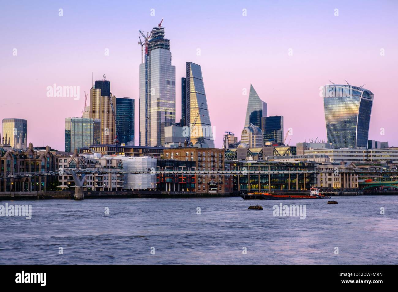London city centre and its buildings during a pink sunset in a clear sky Stock Photo