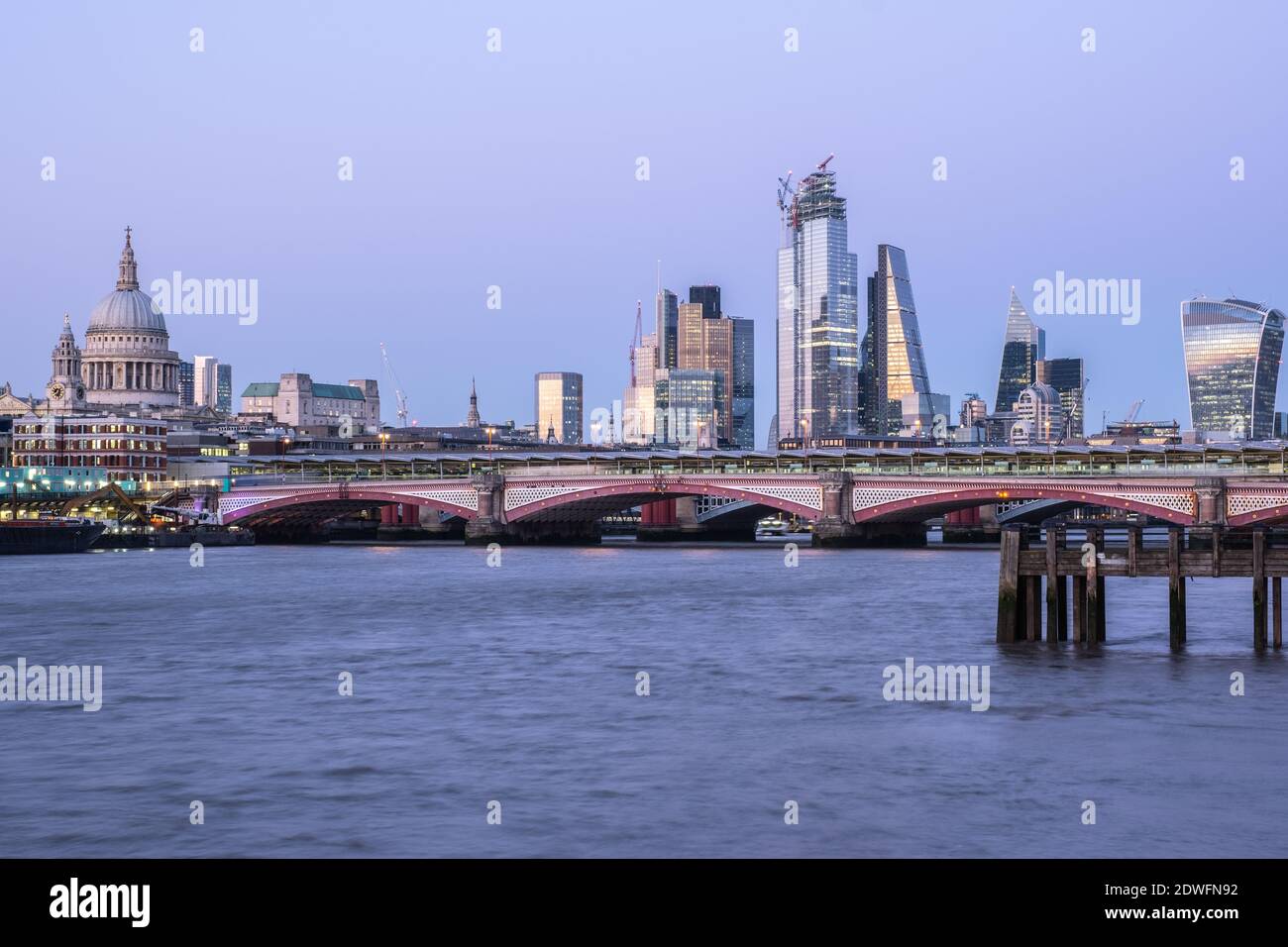 London city centre and its buildings during a pink sunset in a clear sky Stock Photo