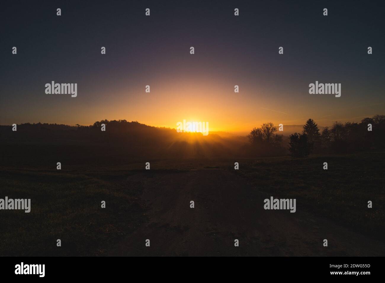 Scenic View Of Silhouette Field Against Sky During Sunset Stock Photo