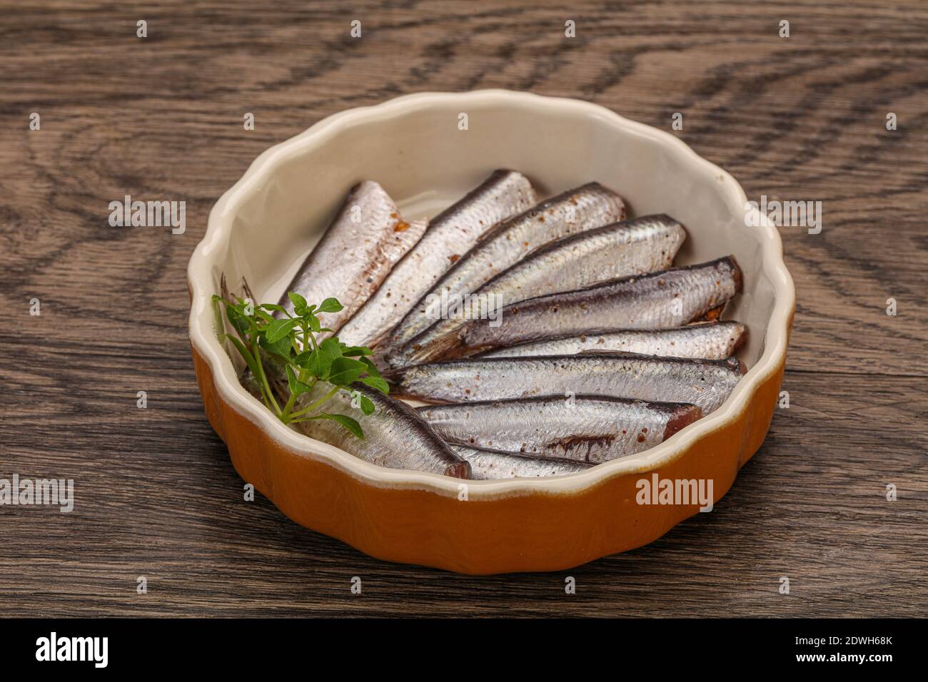 Anchovies fish snack in the bowl served basil leaves Stock Photo - Alamy