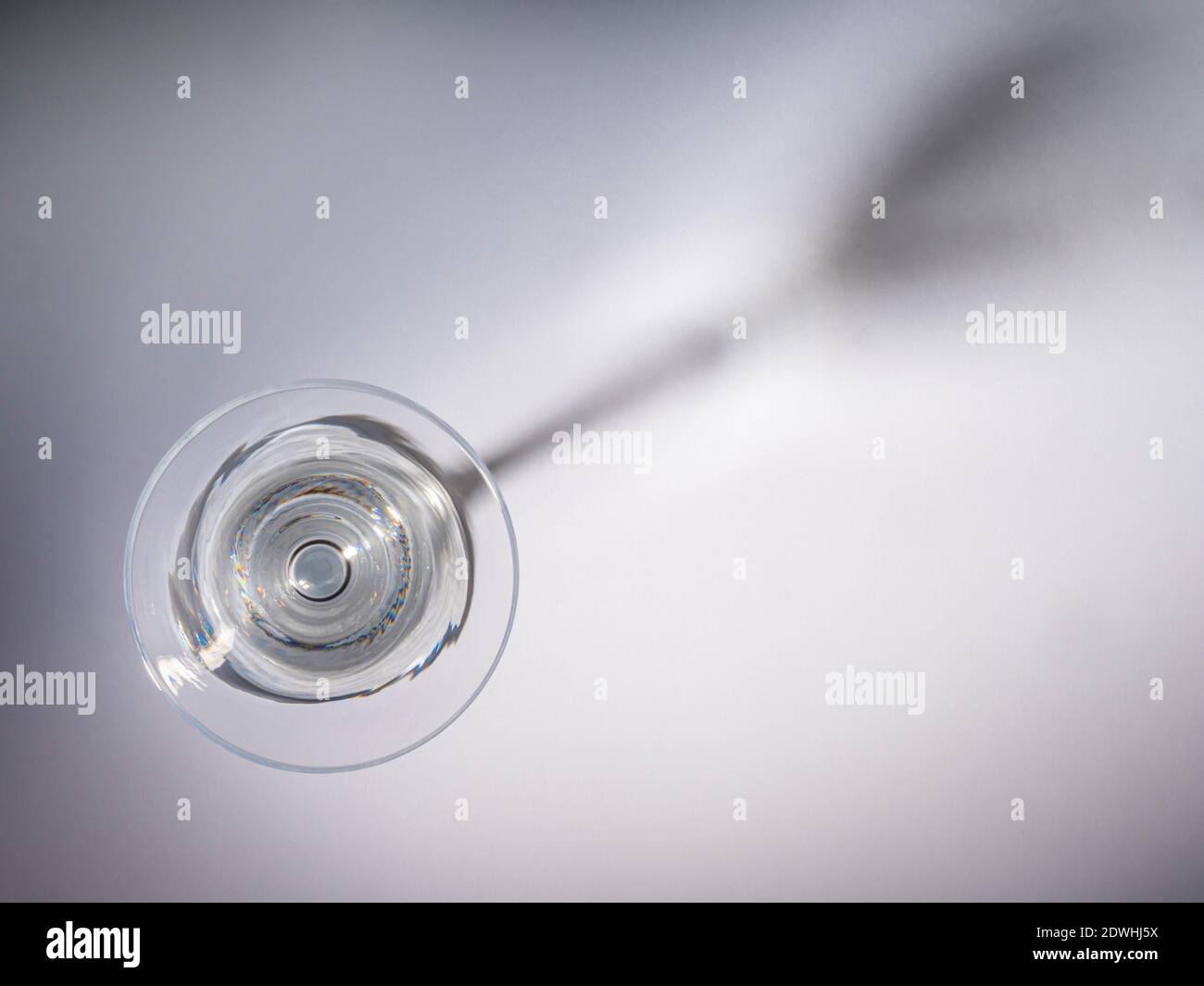 Empty cocktail glass seen from above with shadow of glass on background. Stock Photo