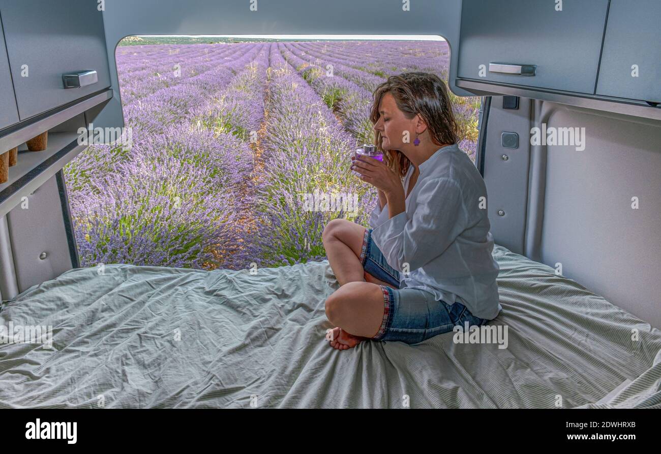 Lavender flower, woman smelling lavender aroma sitting in a camper, Stock Photo