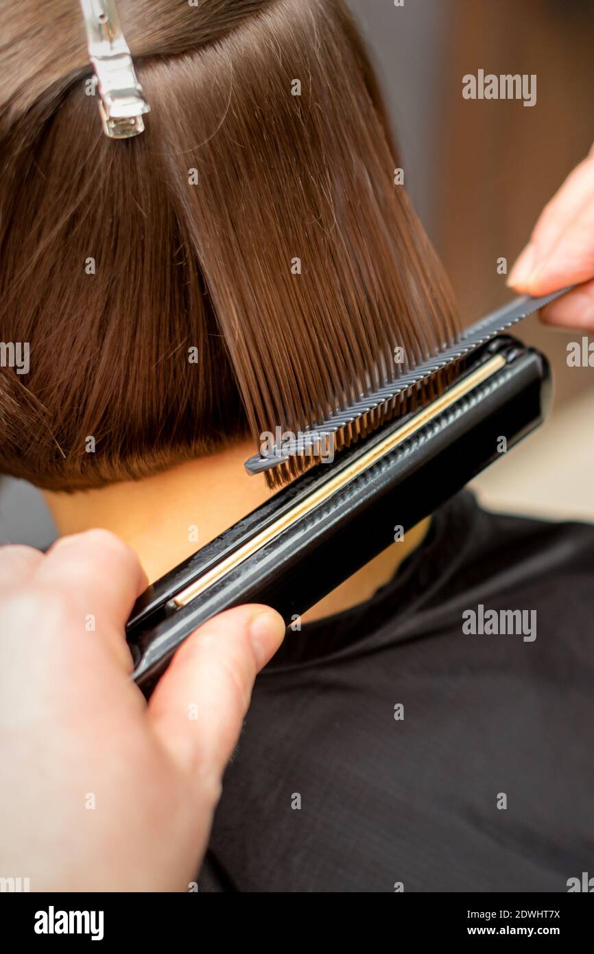 Close up of the hairdresser straightening the short hair of a female client with a hair straightening iron in a beauty salon Stock Photo - Alamy Close up of the hairdresser straightening the short hair of a female client with a hair straightening iron in a beauty salon Stock Photo - Alamy