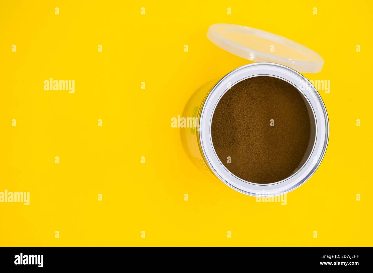 A top view shot of freshly ground coffee in a can isolated on yellow