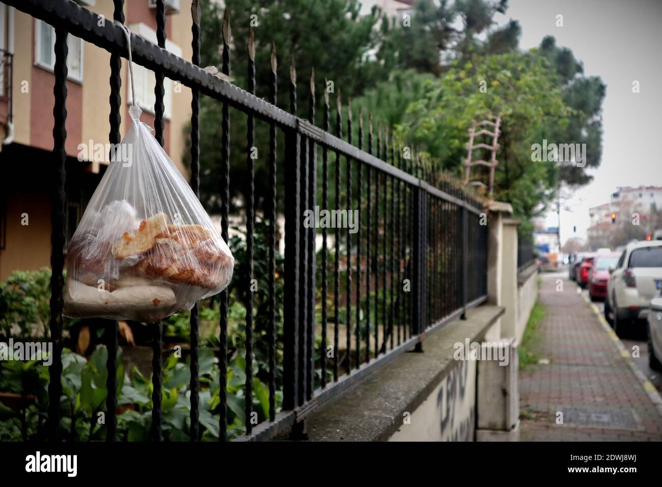 A plastic bag with stale bread hangs on a fence in Istanbul. The stale bread is supposed to be for poor people, but it usually goes mouldy. Stock Photo