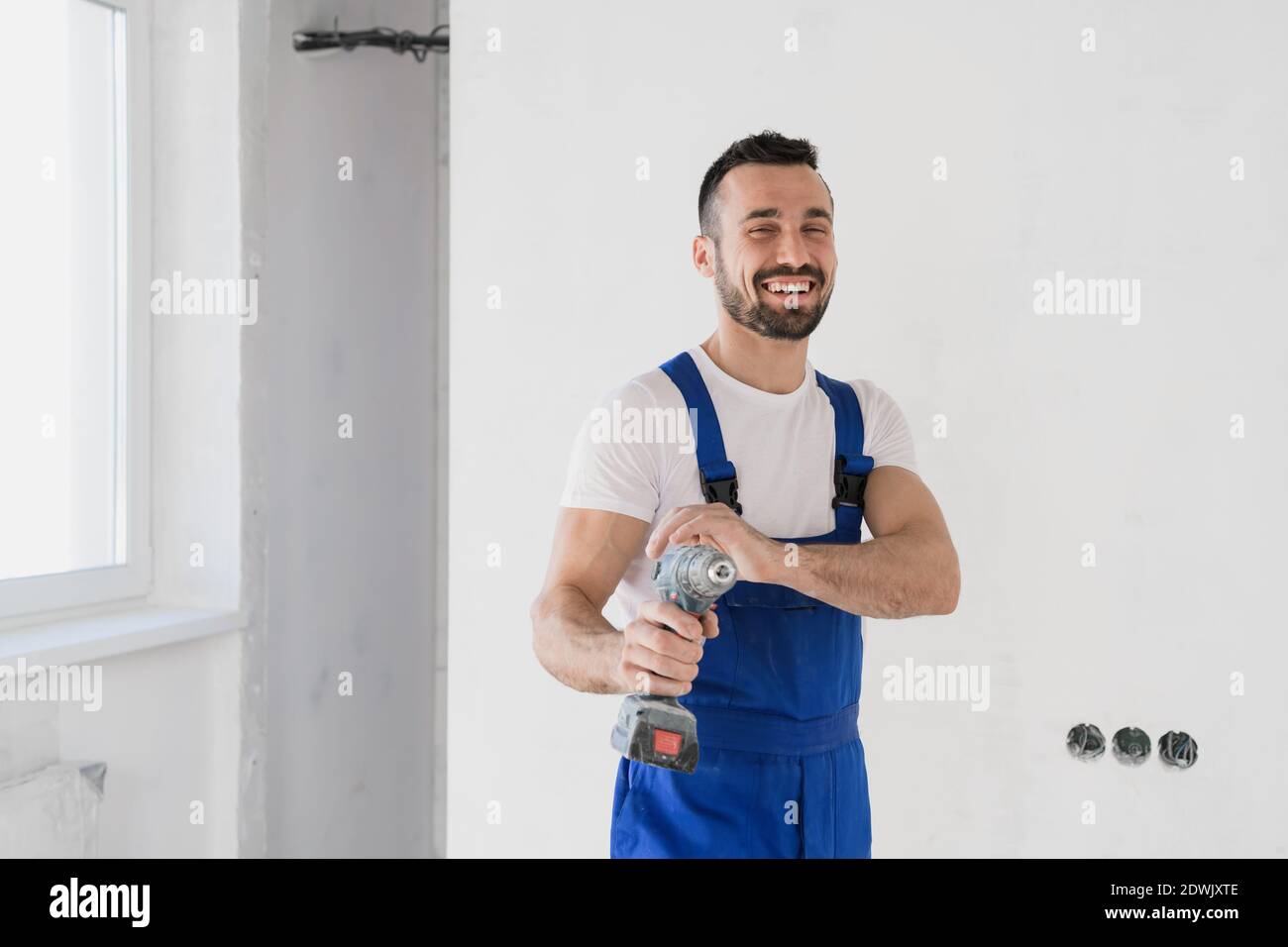 A foreman holds a drill in his hand and looks at the camera Stock Photo