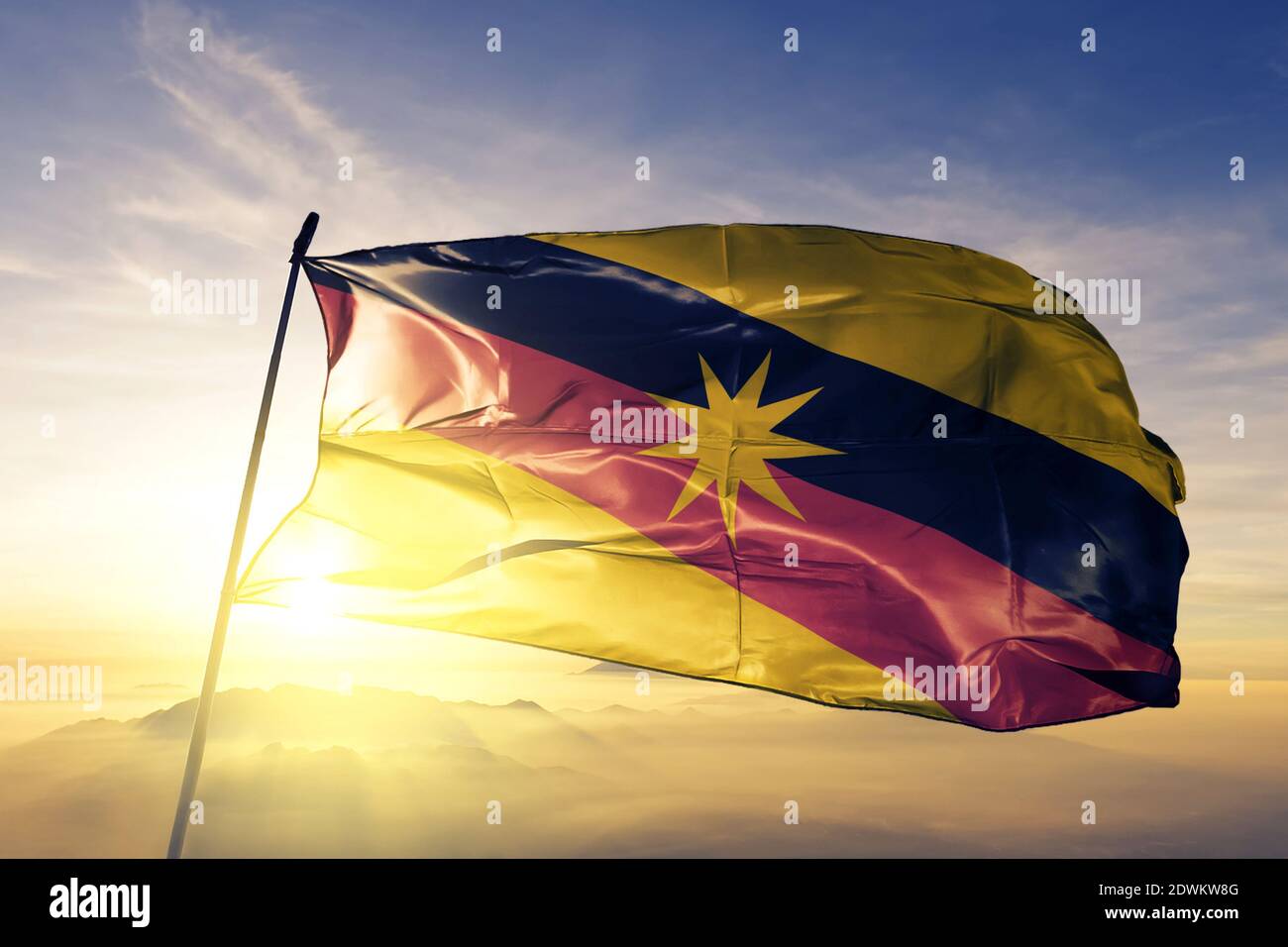 Sarawak state of Malaysia flag waving on the top sunrise mist fog Stock Photo