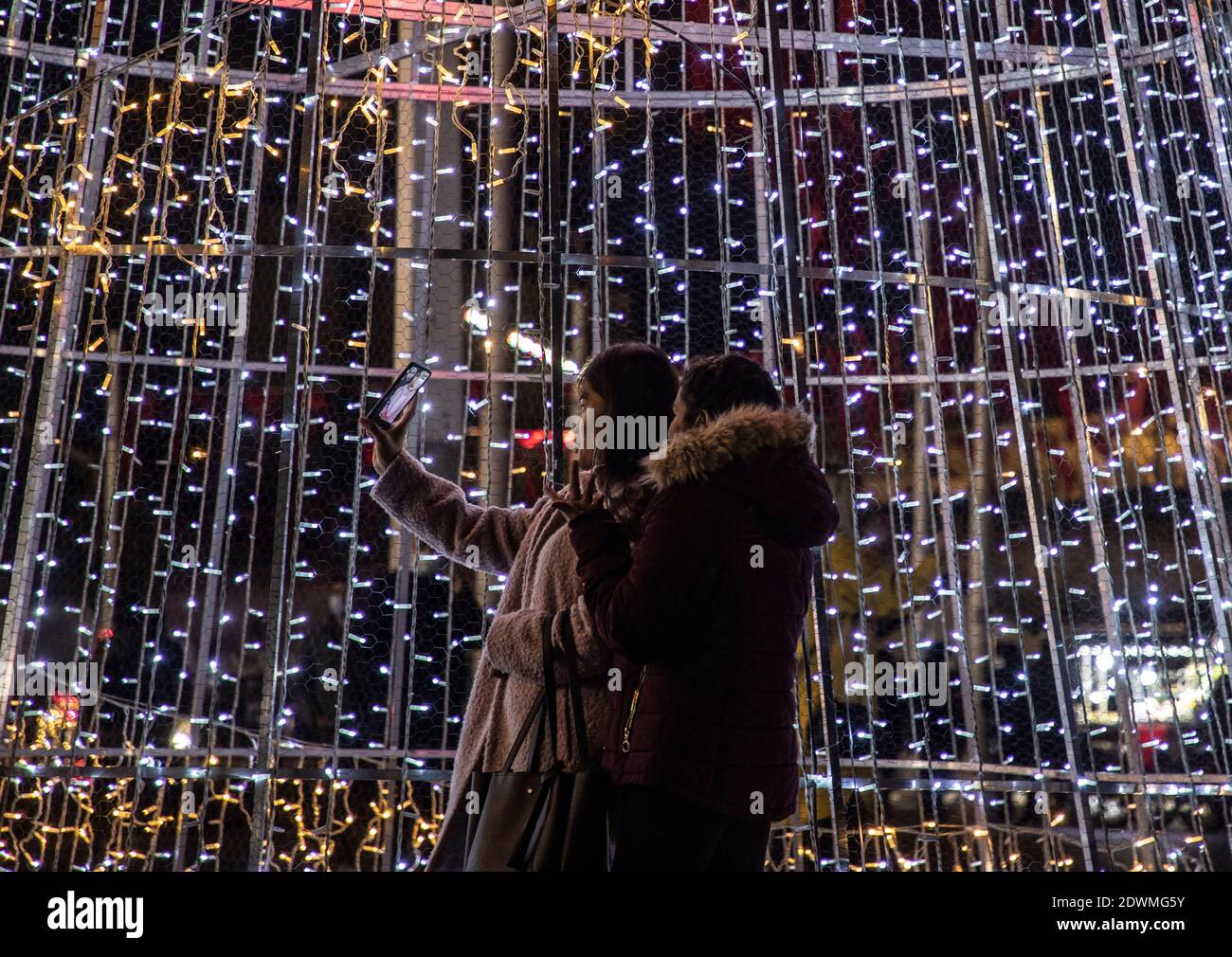 Istanbul, Turkey. 22nd Dec, 2020. People take selfies in front of Christmas decorations in Istanbul, Turkey, Dec. 22, 2020. TO GO WITH 'Feature: Turkey counts down to New Year celebration amid pandemic' Credit: Osman Orsal/Xinhua/Alamy Live News Stock Photo