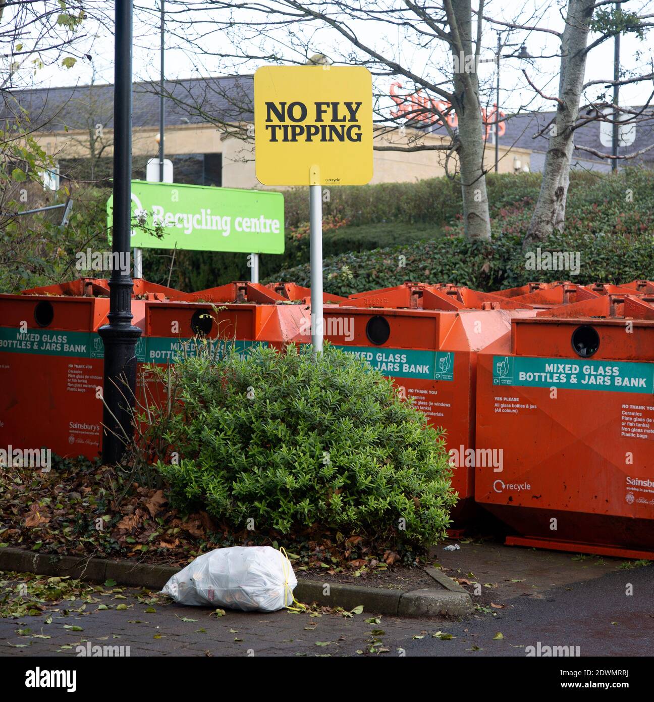 Rubbish bag dumped beneath No Fly Tipping sign, Sainsbury's recycling centre, Calne, England Stock Photo