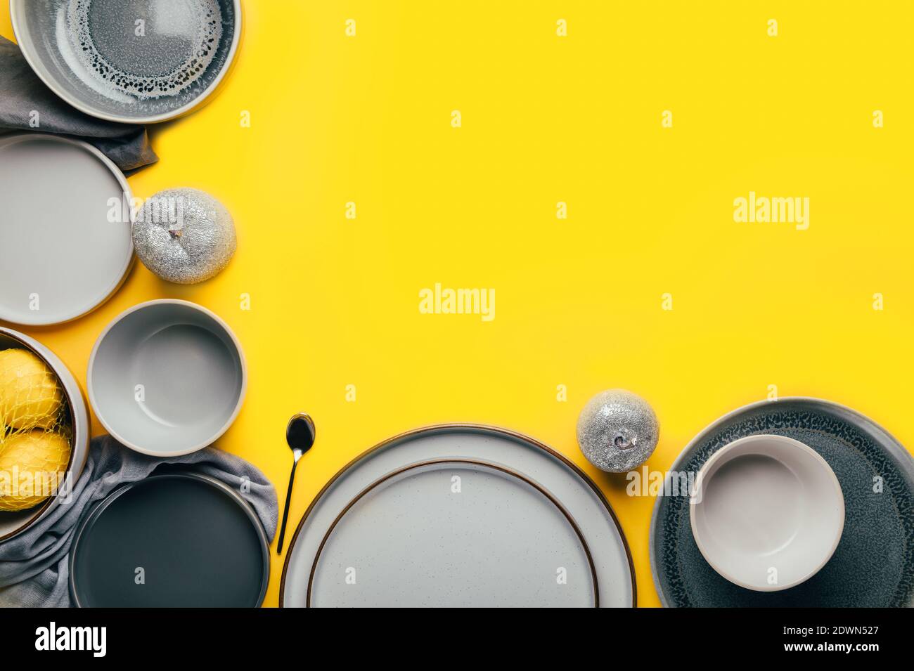 Gray empty ceramic plates on yellow Stock Photo