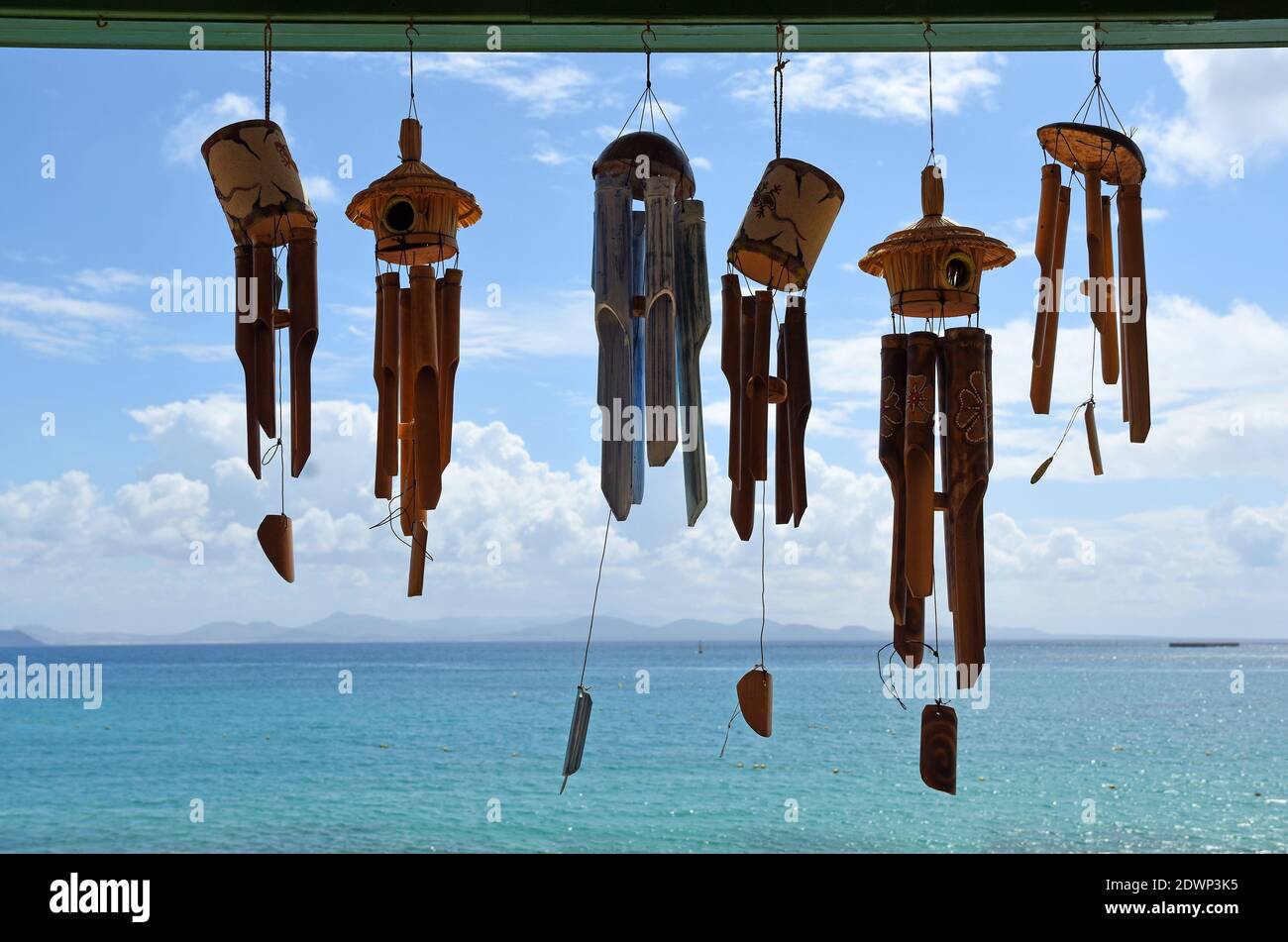 Wind Chimes against Blue Sky with clouds and Sea. Stock Photo