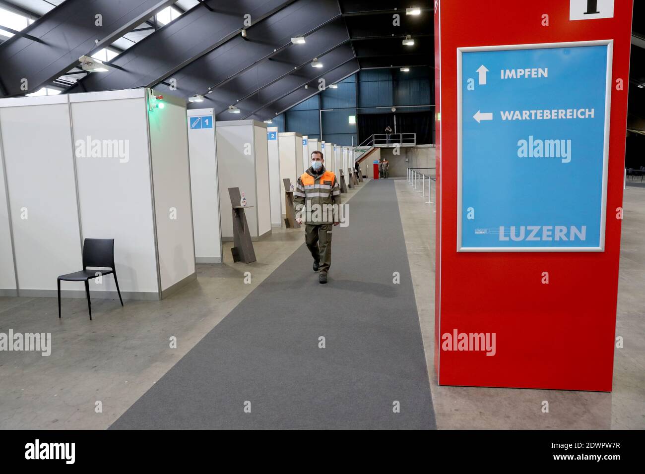 A member of the Swiss civil protection walks in front of vaccination cabins  at the Messe Luzern fairground, as the spread of the coronavirus disease  (COVID-19) continues, in Lucerne, Switzerland December 23,