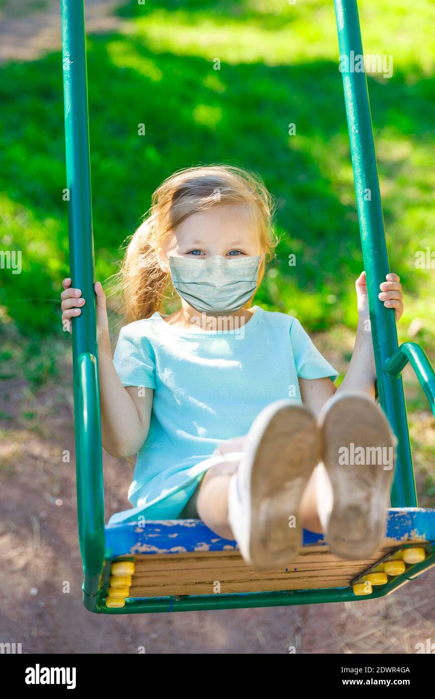 girl in a blue dress swinging on a swing Stock Photo - Alamy