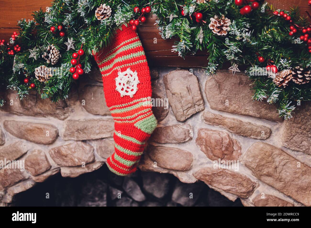 Christmas stockings hanging over a fireplace with candles on the
