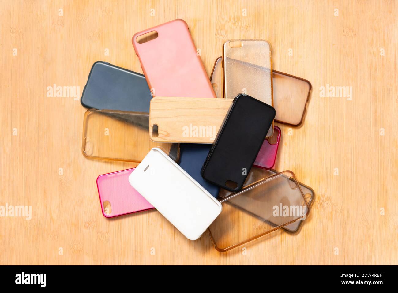 Pile of multicolored plastic back covers for mobile phones on wooden table background Stock Photo