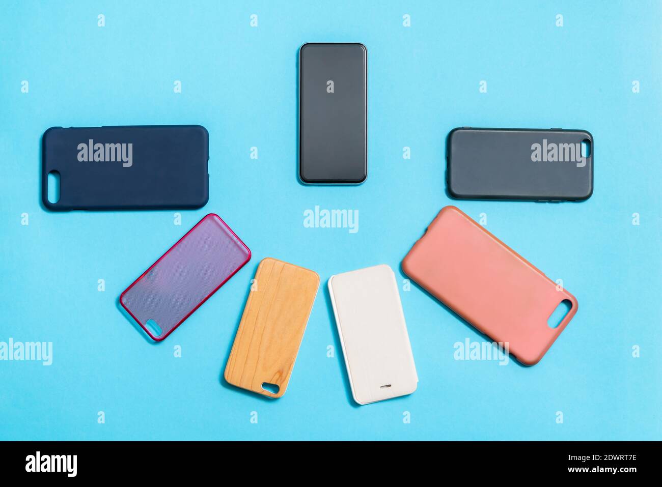 Pile of multicolored plastic back covers for mobile phones on blue