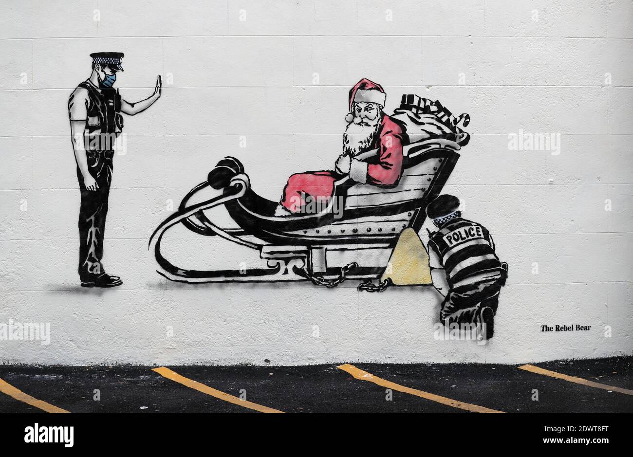 New artwork created by street artist The Rebel Bear near Leith Walk, Edinburgh, which features Santa Claus on his sleigh with his sleigh being clamped by a police officer. Stock Photo