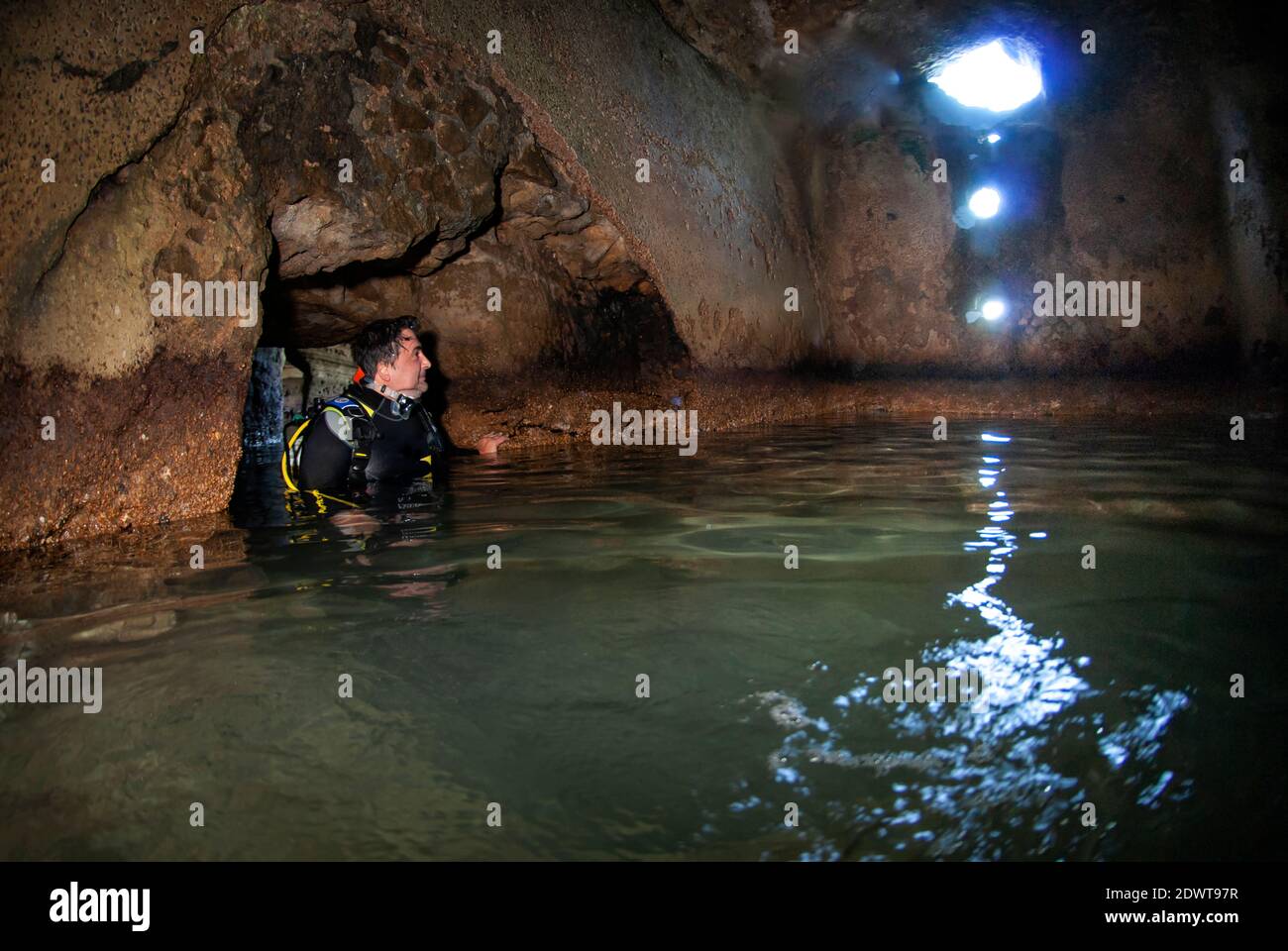 Scuba diver coming out of a submerged ancient Roman market room. Submerged ancient Roman building ruines. Dragonara caves, Miseno. Campi Flegrei (Phle Stock Photo