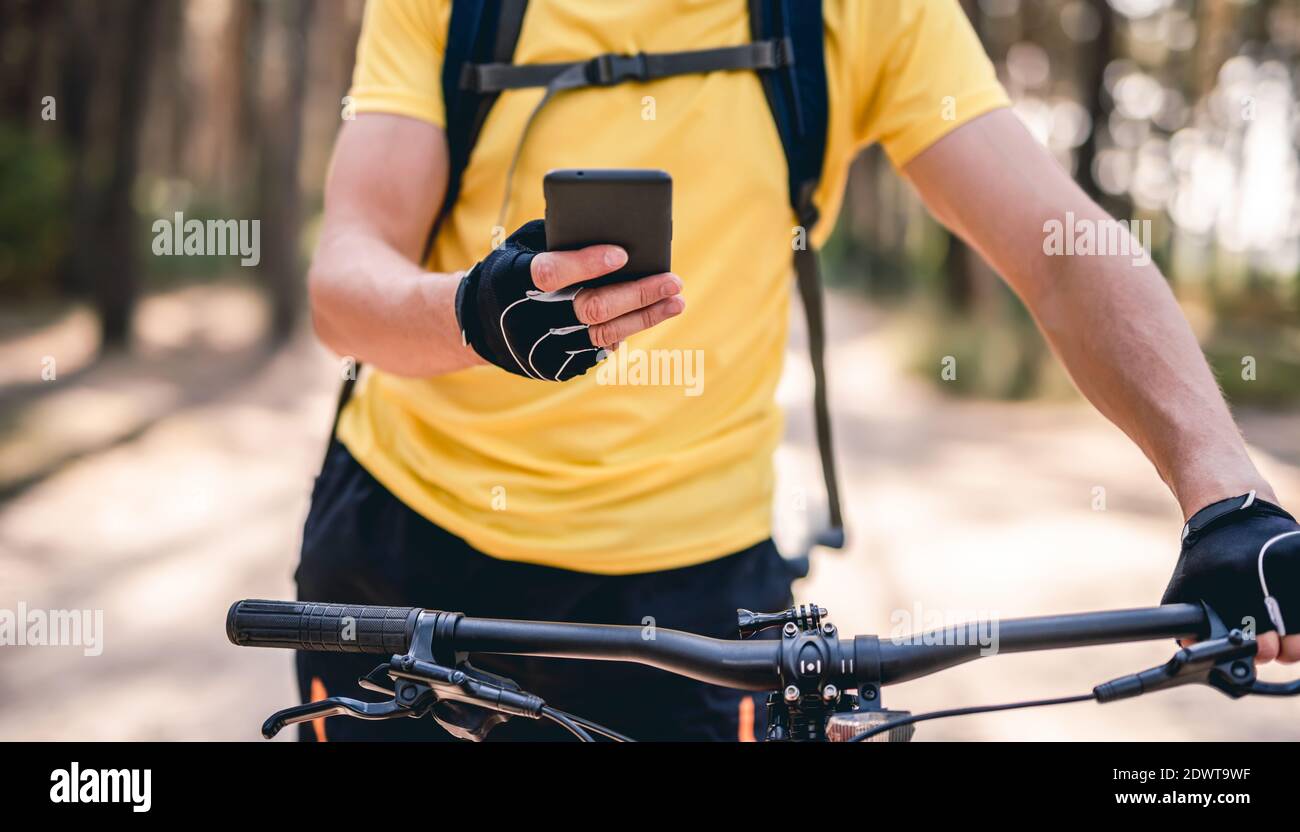 Man using smartphone for navigation during bicycle ride Stock Photo