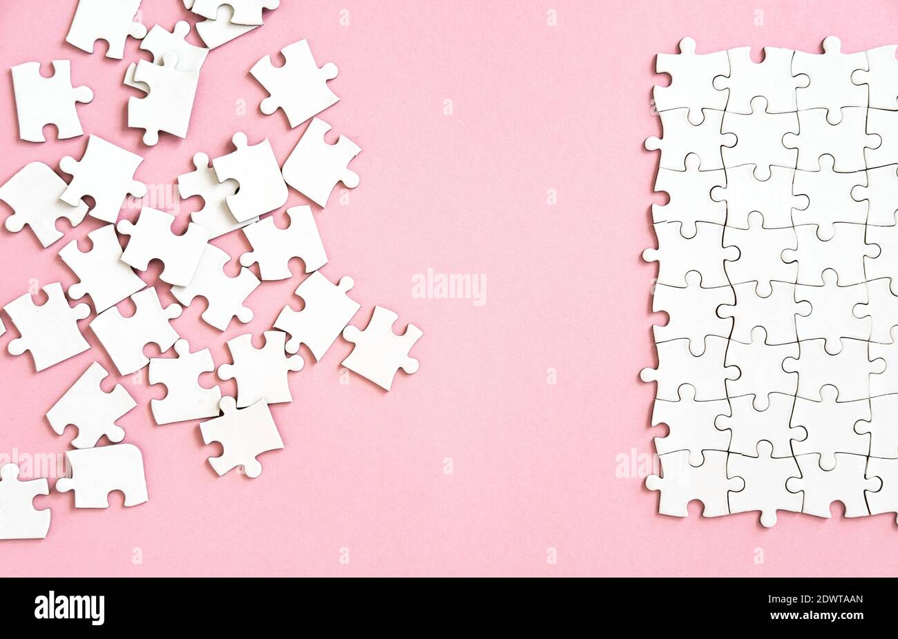 white puzzle pieces on pink background Stock Photo