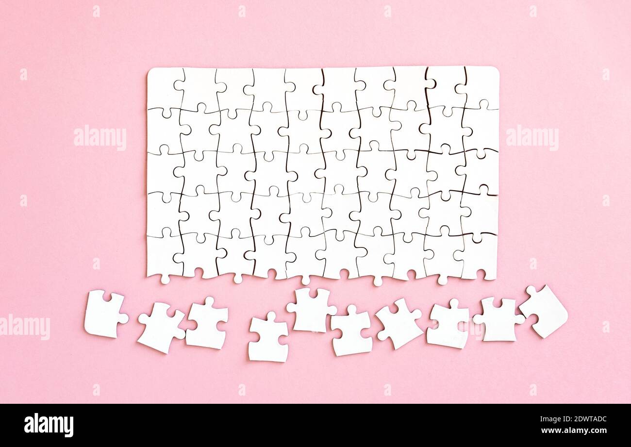Unfinished white jigsaw puzzle, top view Stock Photo