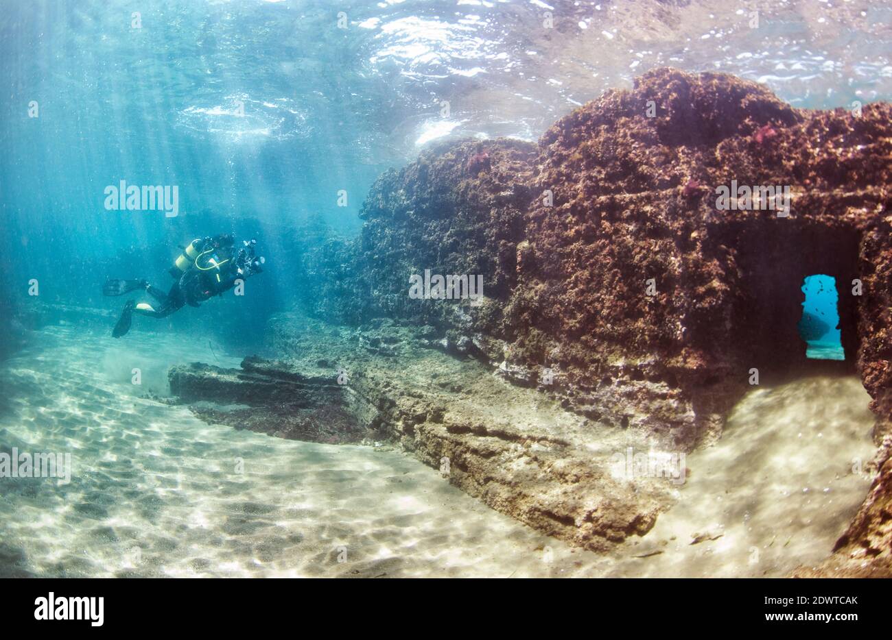 Scuba diver swimming through submerged ancient Roman building ruines. Dragonara caves, Miseno. Campi Flegrei (Phlegraean Fields), Naples, Italy Stock Photo