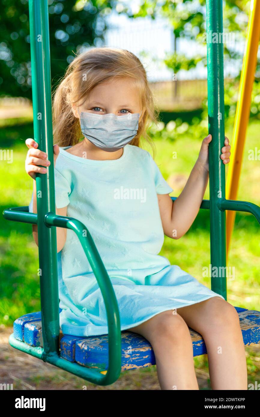 girl in a blue dress swinging on a swing Stock Photo - Alamy