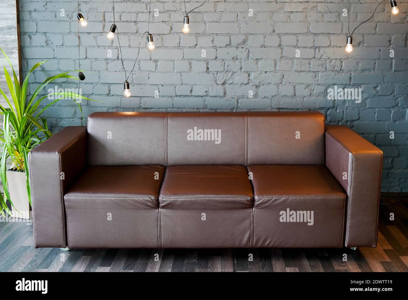 brown leather sofa and stone wall with modern lighting, interior office concept Stock Photo
