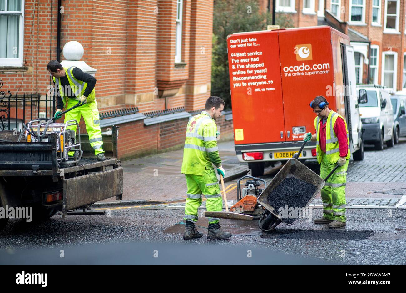 Pic shows: Team of roadworkers filling a pothole in the road in Highgate North London     picture by Gavin Rodgers/ Pixel8000 Stock Photo