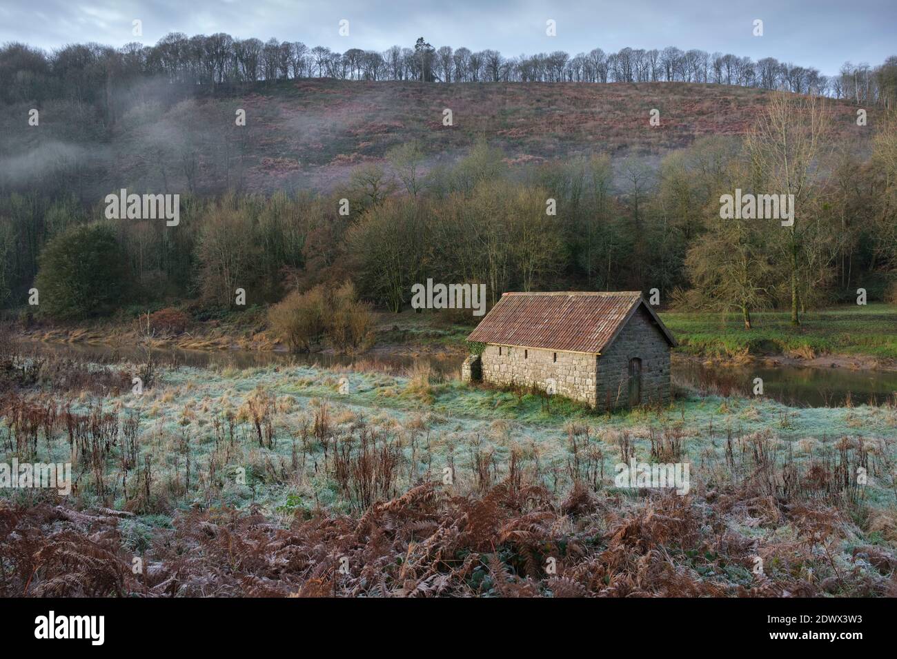 Boat house alongside a mist covered river Wye at Brockweir. Stock Photo