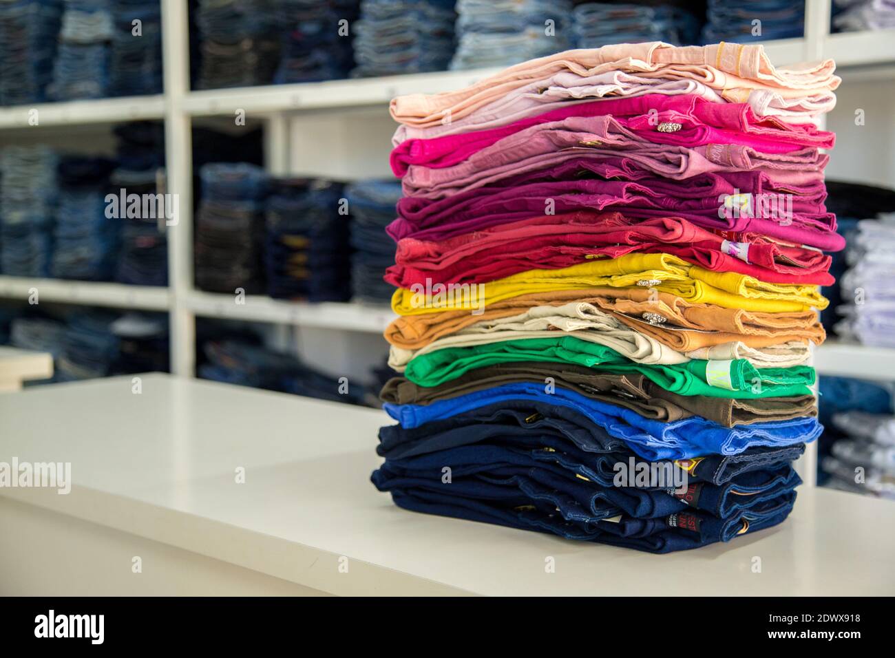 Multi Colored Stacked Jeans On Table In 