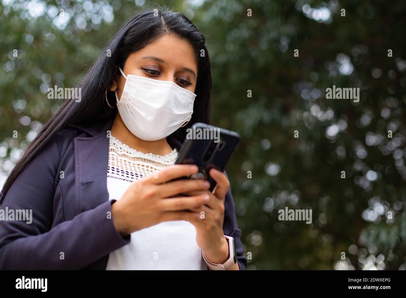 Latin businesswoman wearing a face mask for protective reasons during the covid 19 pandemic. Stock Photo