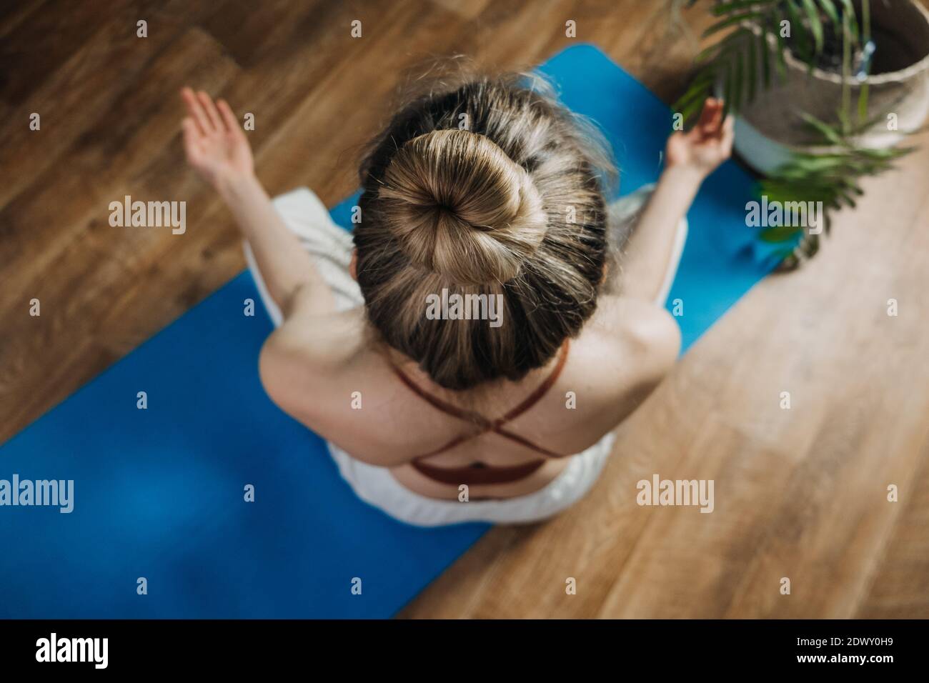 Young woman sitting on yoga pose enjoy meditation do yoga exercise at home. Mental health, self care, No stress, healthy habit, mindfulness lifestyle Stock Photo