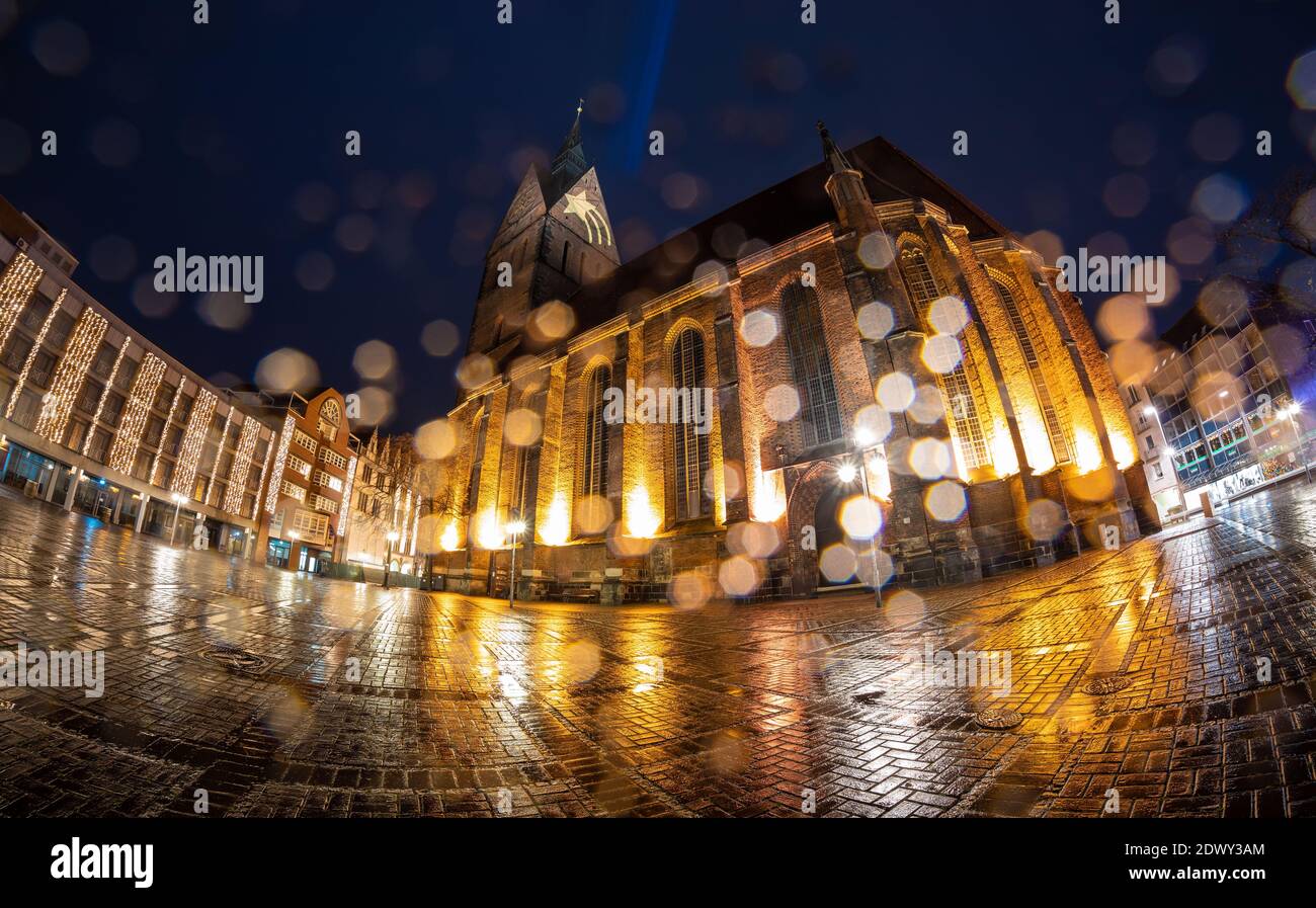 Hanover, Germany. 23rd Dec, 2020. A star is projected onto the tower of the Marktkirche while raindrops bead on the objective lens (shot with fisheye lens). The light artwork is intended to give people hope and confidence during the Christmas holidays overshadowed by the Corona pandemic, the Marktkirche congregation announced. Credit: Moritz Frankenberg/dpa/Alamy Live News Stock Photo