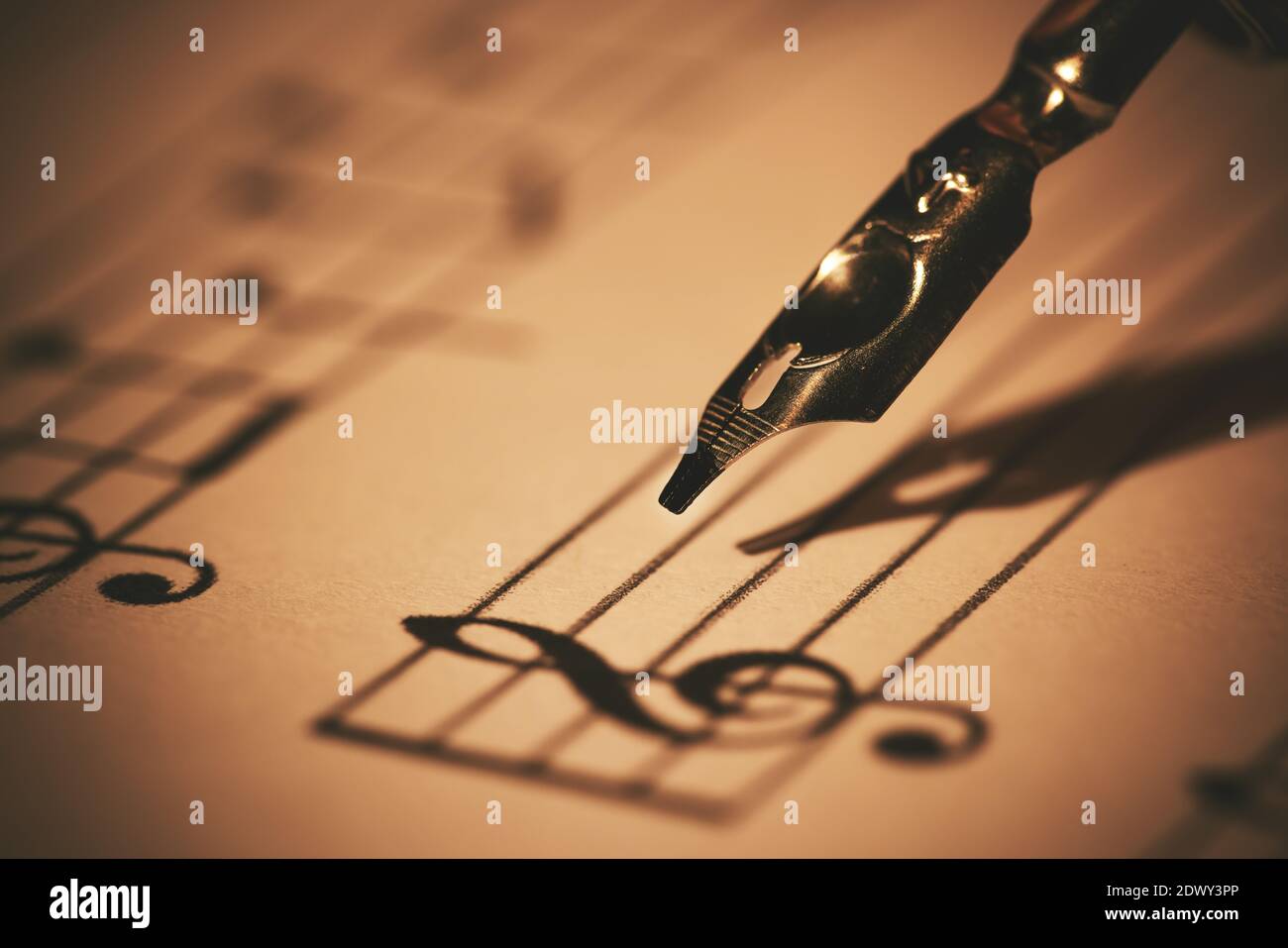 writing musical notes on sheet with quill pen and ink. music education. closeup Stock Photo